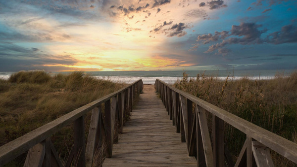 Sendero costero con barandas y cielo despejado